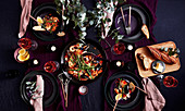 Meeresfrüchte-Paella serviert mit Brot und Wein auf gedecktem Tisch (Aufsicht)