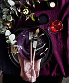 Winter table setting in purple tones decorated with twigs (top view)