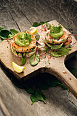 Open fish burgers with rice crackers and avocado cream