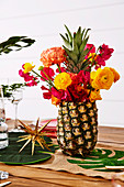 Bouquet of flowers in pineapple vase on table decorated for Christmas
