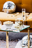 Small bowl with popcorn, drink and star decoration on a glass coffee table