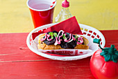 Hot Dog with pork sausage with beetroot crisps, mint and beetroot sauce