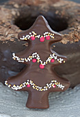 A chocolate-glazed gingerbread Christmas tree with sprinkles