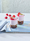 Layered desserts with raw brownie and raspberry and coconut cream