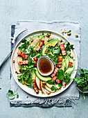 Apple and avocado salad with ginger bacon strips, watercress and pistachios