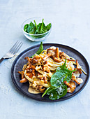 Spaghetti with chanterelle mushrooms and a creamy sauce served with a spinach salad