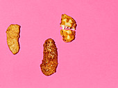 Three schnitzel on a pink surface (seen from above)