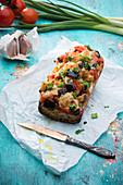 Baguette topped with colourful vegetables and almond cheese (vegan)