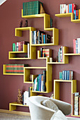 Yellow designer bookshelves on dark red wall