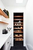 Narrow white room with view into pantry