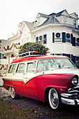 Classic car with decorated Christmas tree on roof rack