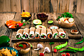 Tortilla wraps with various fillings surrounded by ingredients