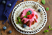 A mini gugelhupf with beetroot, frosting, sugar flowers, fresh blueberries and mint