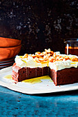 Fudgy chai cake with a cream topping, sliced