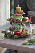 Homemade cake stand with baubles, cones and branches