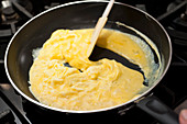 Preparing scrambled eggs in a pan