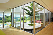 Cubic glass light well containing garden in modern, architect-designed house