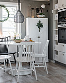 Windsor chairs at dining table in grey-and-white kitchen-dining room
