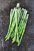Green asparagus with soil on a wooden background