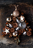 Weihnachtsdekoration aus Kugeln, Zapfen und Sternen in Tannenbaumform