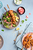 Chicken harrisa skewers with couscous, salad, pickled radish and yoghurt, cucumber and mint dip