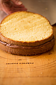A cake being made: cake layers being placed together
