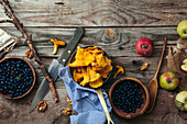 Blueberries, apples and chanterelle mushrooms on gray rustic background