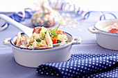 Penne pasta salad with pineapple and mayonnaise-yoghurt dressing in a mini baking dish
