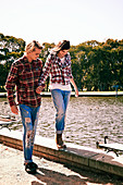 Junges Pärchen im Partner-Look (Kariertes Hemd und Jeans) am Fluß