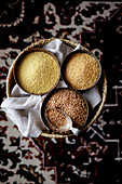 Glutenfreies Getreide: Buchweizen, Leinsamen und Hirse in Schälchen (Aufsicht)
