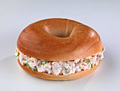 Bagel belegt mit Thunfischsalat vor weißem Hintergrund