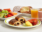 Breakfast with pastries, fruit, yogurt and orange juice