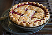 Lattice Top Cherry Pie with Powdered Sugar on Picnic Table