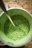 Wheatgrass powder in a glass with a spoon