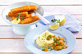 Mashed potatoes with a pea and carrot medley and fish fingers