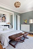 Leather stools at foot of bed in white-and-grey bedroom