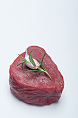 A raw fillet of beef with garlic and rosemary
