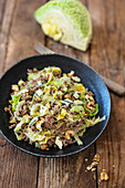 Savoy cabbage with minced meat and walnuts in a pan