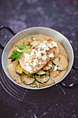 Turkey and Zucchini in a cream sauce with goat cheese in a pan