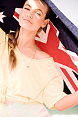 A young woman wearing a yellow top with an Australian beach towel