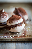 Macaroons with chocolate cream and cocoa powder