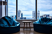 Zwei blaue Sitzsäcke und Beistelltisch vor Fenster