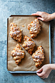 Frisch gebackene Mandel-Croissants auf Backblech (Aufsicht)