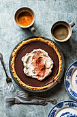 Chocolate pie with whipped cream on top and dusted with cocoa powder