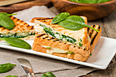 Sandwich with cheese and spinach on wooden background