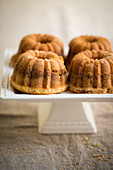 Four mini coffee cakes with almonds on a cake stand