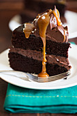 A slice of chocolate cake with caramel sauce