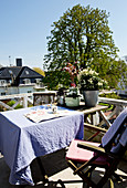 Tisch mit lila Tischdecke und Stühle auf Balkon