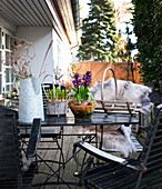 Gartentisch mit Frühlingsblumen auf Terrasse