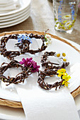 Wicker wreaths decorated with spring flowers to be used as napkin rings